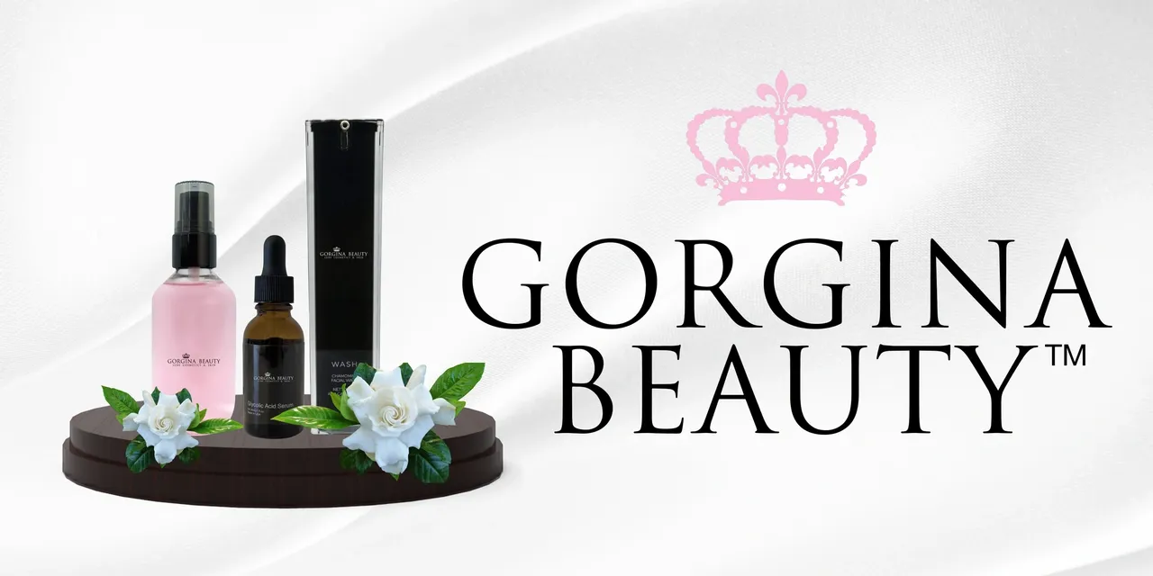 A set of luxury skincare products including a spray bottle, a dropper bottle, and a box, displayed on a wooden stand with a white flower and green leaves, beside the text "Gorgina Beauty" with a pink crown.