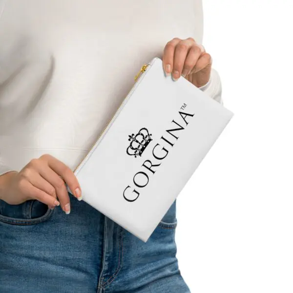 A person holds a white Cosmetic Bag with the word "Gorgina" and a crown logo printed on it.