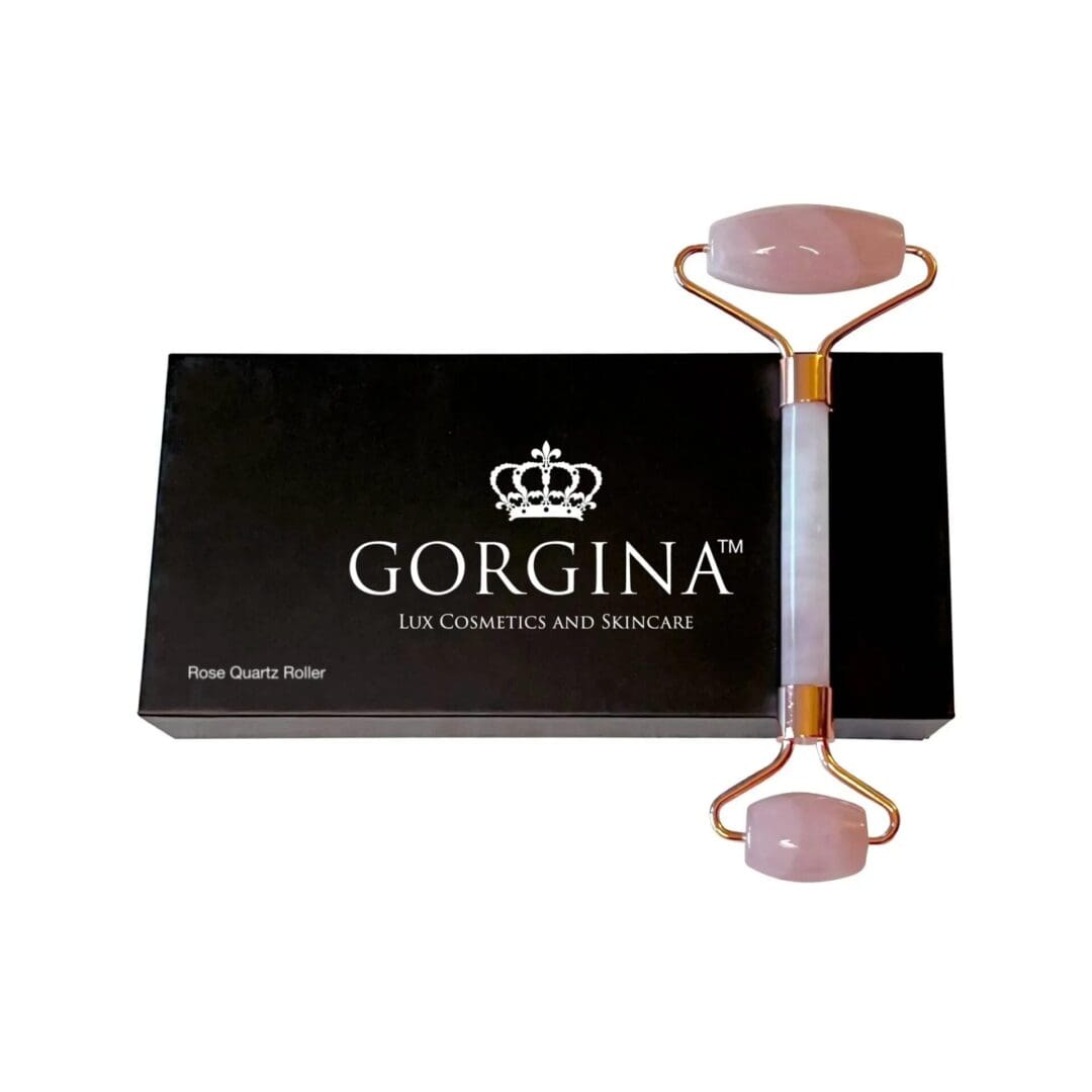 A rose quartz roller is placed on top of a black Gorgina Lux Cosmetics and Skincare box.