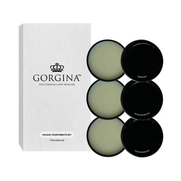 Box labeled "Gorgina Lux Cosmetics and Skincare" with three open circular containers of cream: Speakeasy, Kyoto Sandalwood, Rose Sandalwood. Text reads "Holiday Scentiments Set, Three-piece set.