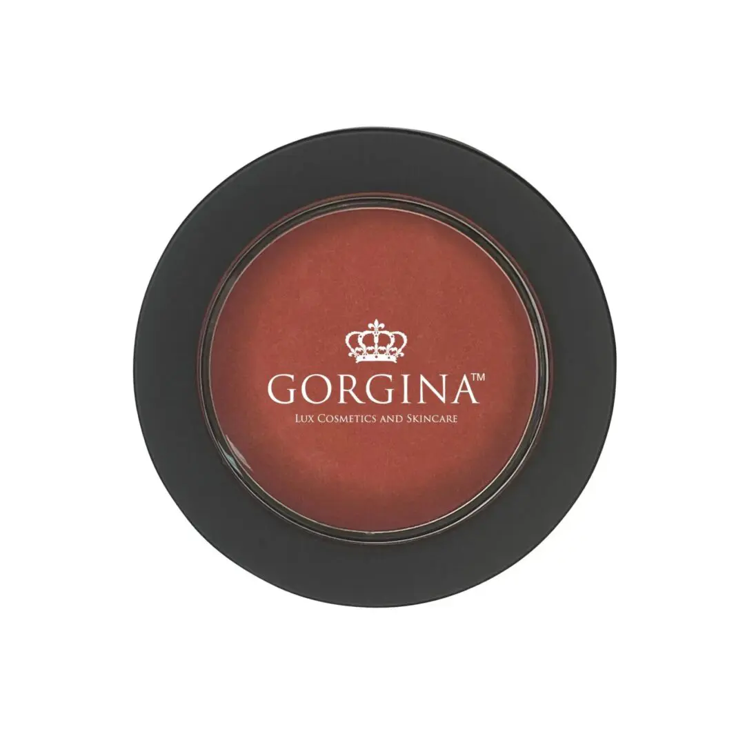 Round makeup compact with a clear lid displaying "Gorgina Lux Cosmetics and Skincare" in white. Dark outer rim with visible product in the center.