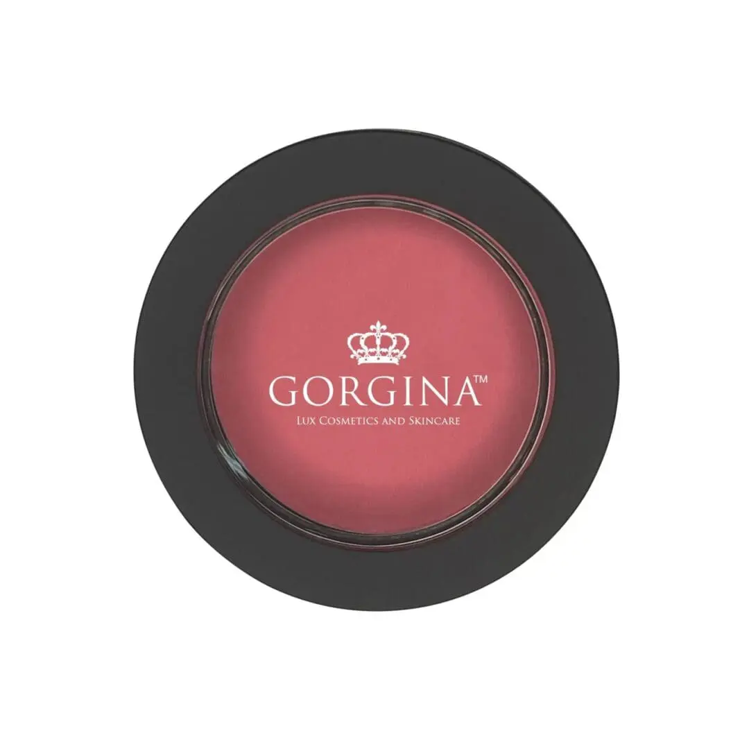 Compact case of Gorgina blusher with a black outer rim. The blusher is a pink shade and has a crown logo and text reading "Gorgina Lux Cosmetics and Skincare" on the front.