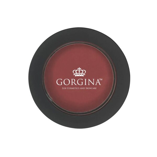 A round, black container of Gorgina Lux Cosmetics and Skincare blush with a maroon shade and a crown logo on the lid.