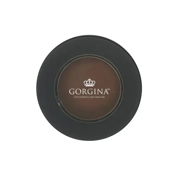 Compact container with a black lid and circular transparent window revealing brown cosmetic product with "Gorgina" logo and text.