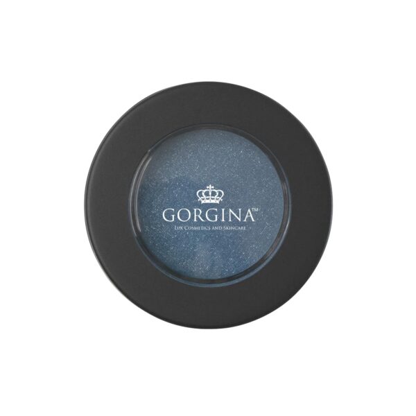 Closed round container of Gorgina Lux Cosmetics eyeshadow with black lid and transparent window, revealing a shimmery blue shade inside.