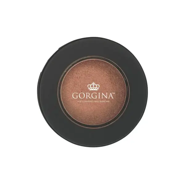 Close-up of a round Gorgina bronzer compact with a clear lid, revealing a shimmery bronze powder inside.