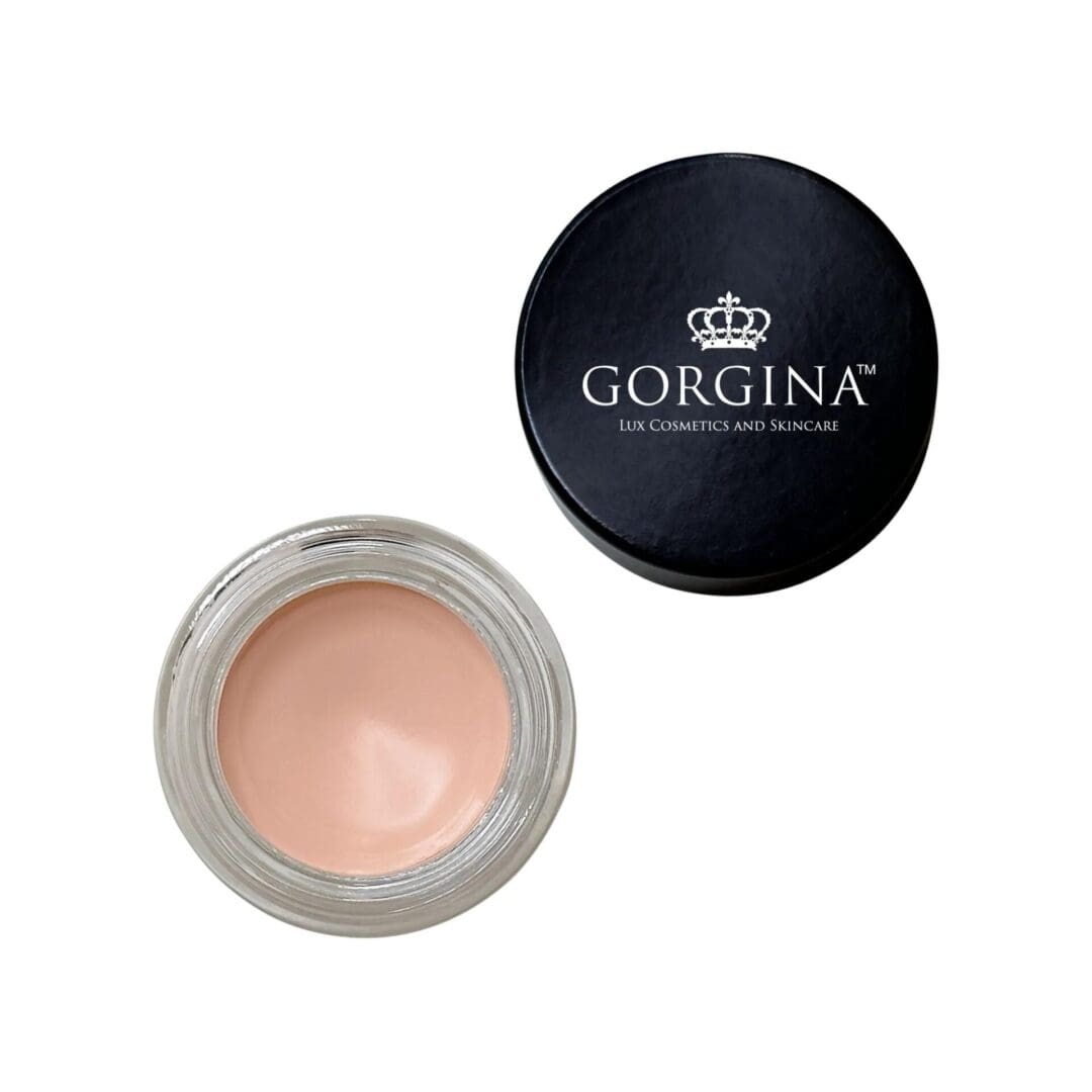 Open jar of Gorgina lux cosmetics cream with beige content, next to a black lid displaying the brand logo and name.