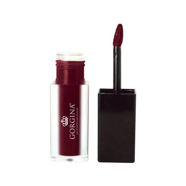 A tube of dark red liquid lipstick with the cap off, showing the applicator wand beside it.