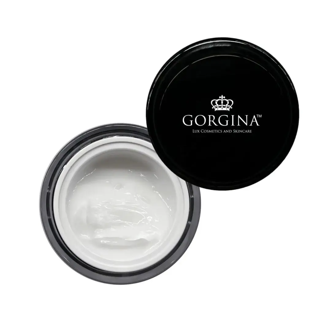 A black-lid jar of Gorgina skincare cream, containing white cream, with the lid partially open.