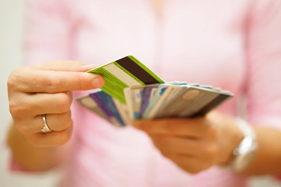 A person holding up two different credit cards.