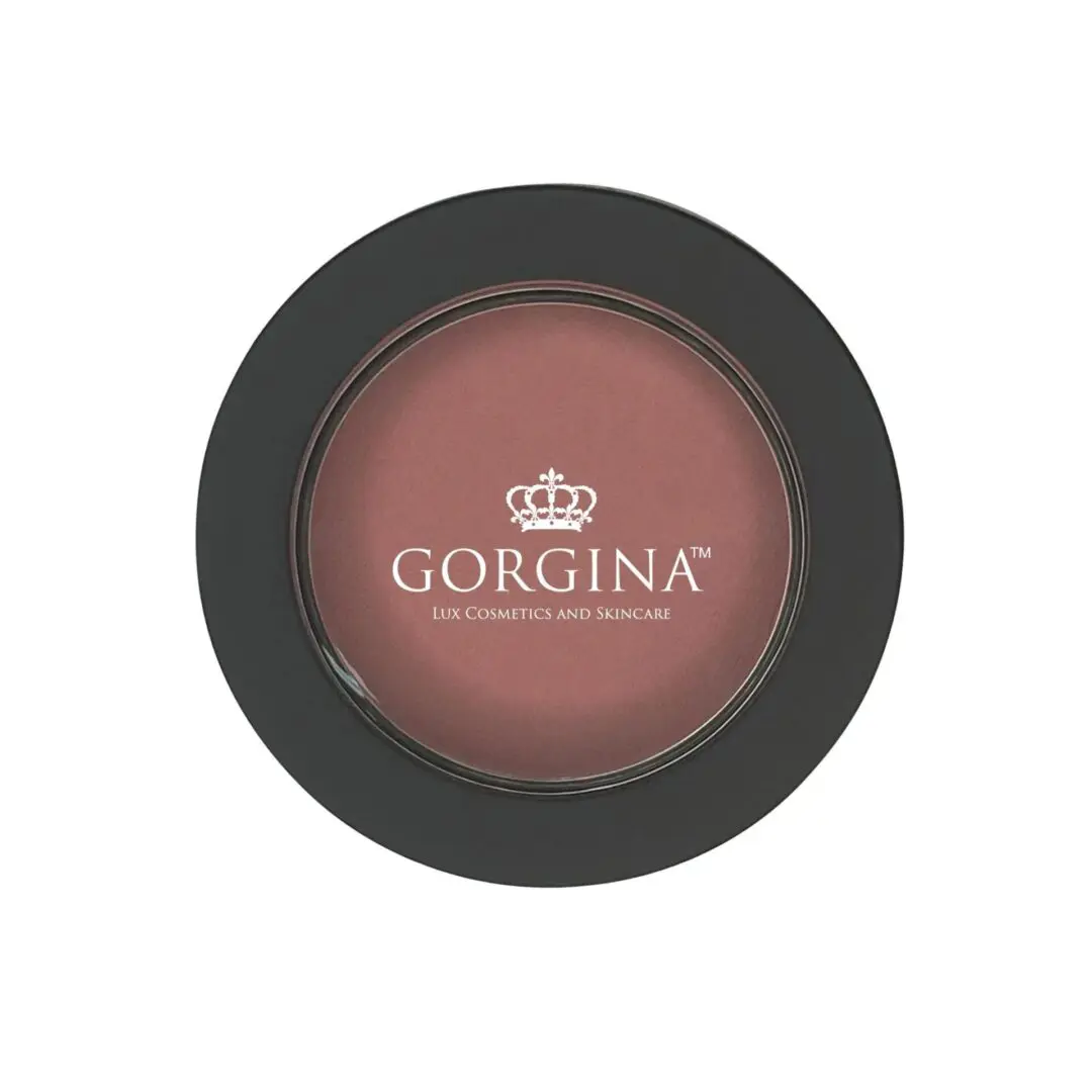 A round container of blush from Gorgina Lux Cosmetics and Skincare with a black rim and a crown logo on the lid.