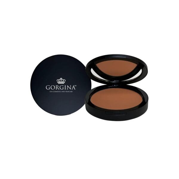 A compact makeup powder with an open lid, displaying the product inside. The lid is black with the brand name "GORGINA" and a crown logo.