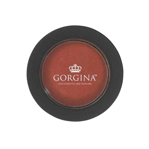 A round container of Gorgina Lux Cosmetics and Skincare blush in a warm reddish shade, viewed from above.