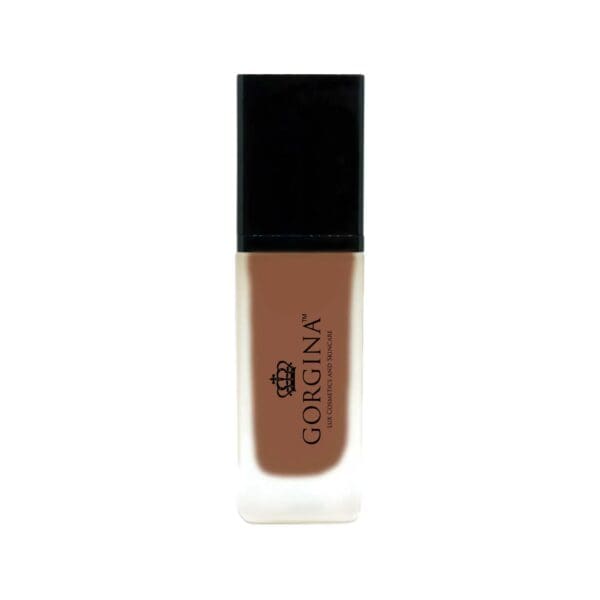 A bottle of Gorgina liquid foundation with a black cap and frosted glass bottle containing medium brown makeup.