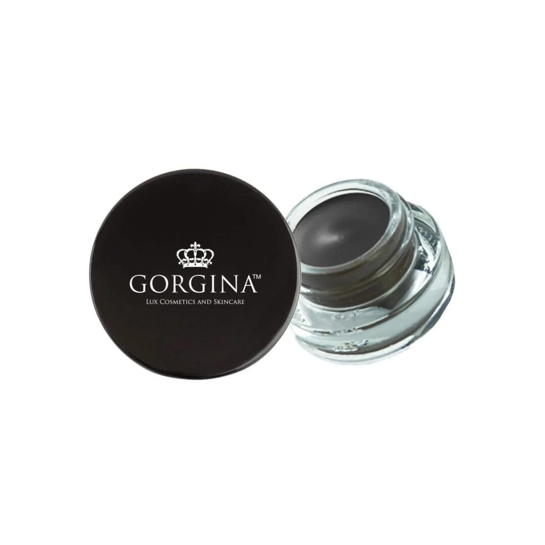 A small glass jar of Gorgina Lux Cosmetics and Skincare product with a black lid, partially opened to reveal a dark cream or gel inside.
